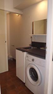 a kitchen with a washing machine and a sink at L'Oustau in Cavaillon