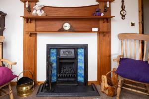 a fireplace with a clock on top of it at Ceol na Mara Guest House in Tarbert