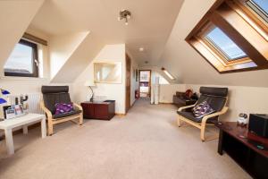 a attic living room with two chairs and a table at Ceol na Mara Guest House in Tarbert