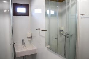 a white bathroom with a sink and a shower at xisto camping in Janeiro de Baixo