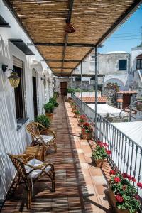 - une terrasse couverte avec 2 chaises et une passerelle en bois dans l'établissement B&B Il Vicolo, à Anacapri