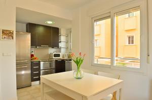 a kitchen with a table and a vase with flowers on it at MyFlats La Palma in El Campello