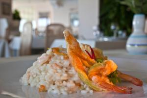 a plate of rice and seafood on a table at Le Querce Resort Sea Thermae & Spa in Ischia