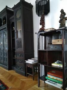 Zimmer mit schwarzen Möbeln und Bücherregal in der Unterkunft Casa Livia Brasov in Braşov