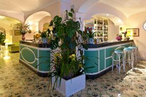 a bar in a room with plants and stools at Le Querce Resort Sea Thermae & Spa in Ischia