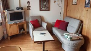 a living room with two chairs and a tv at Chalet uf em Stutz 1 in Grindelwald