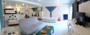 ein großes Wohnzimmer mit einem Sofa und einer Küche in der Unterkunft Le Mas Des Oliviers in Agde