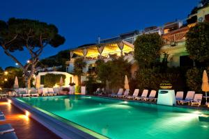 a swimming pool in front of a hotel at night at Le Querce Resort Sea Thermae & Spa in Ischia