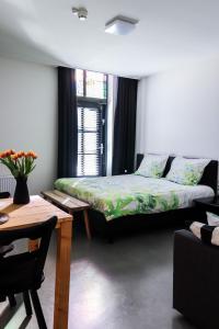 a room with two beds and a table and a couch at Bij Jans in Hilvarenbeek