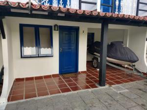 a small house with a blue door and a boat at RESIDENCIA DOS LEAIS in Arraial do Cabo