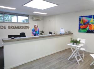 Una donna in piedi dietro un bancone in un ufficio di Bungalowpark De Bremerberg a Biddinghuizen