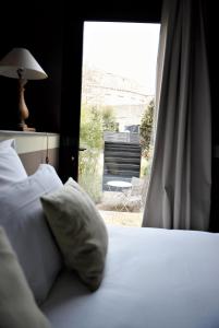 um quarto com uma cama e uma janela com uma cadeira em Hôtel Particulier - La Chamoiserie em Niort