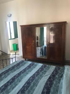 a bedroom with a large wooden cabinet and a bed at Casa Cardi in Sperlonga