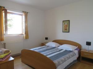 a bed in a bedroom with a window and a bed sidx sidx sidx at Apartmani Prova in Tisno