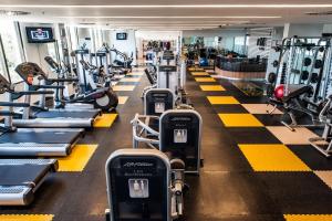 a gym with a row of treadmills and machines at Gran Bourbon Asunción Hotel in Asuncion