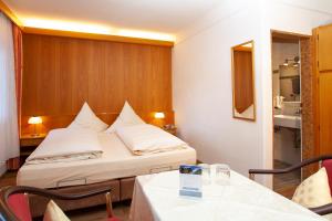 una camera d'albergo con letto, tavolo e sedie di Pension Bavaria a Mittenwald