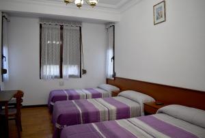 Tempat tidur dalam kamar di HOSTAL OVIEDO