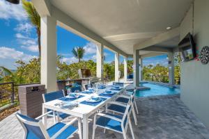 a white table and chairs on a patio with a pool at Nirvana Shores in Stuart