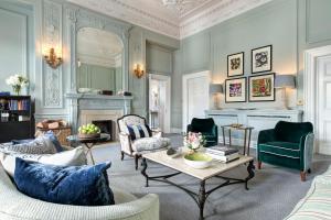 a living room with blue furniture and a fireplace at The Balmoral Hotel in Edinburgh