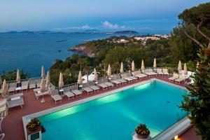 a beach with a pool, chairs, and a swimming pool at Le Querce Resort Sea Thermae & Spa in Ischia