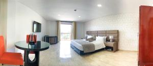 1 dormitorio con 1 cama, 1 mesa y 1 silla en Hotel Majams Resort, en San Gil