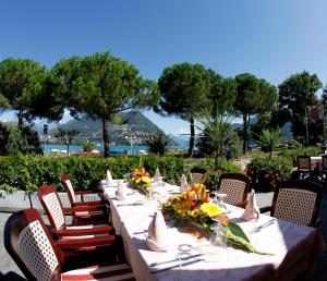 a long table with chairs and flowers on it at Hotel Victoria in Lugano