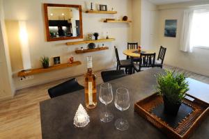 uma sala de jantar com uma mesa e uma garrafa de vinho em Côté Terrasse em Apt