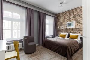 een slaapkamer met een bed en een bakstenen muur bij Somnia Apartments in Vilnius