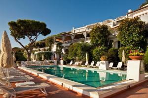 a hotel with a swimming pool and chairs and a building at Le Querce Resort Sea Thermae & Spa in Ischia