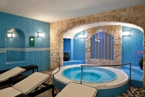 a bathroom with a tub with chairs in it at Le Querce Resort Sea Thermae & Spa in Ischia