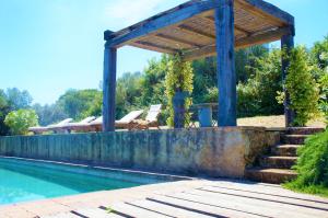 una piscina con gazebo accanto a una piscina di L'Uliveto a Porto Ercole