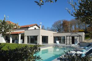 a house with a swimming pool in front of it at Villa au coeur du Gers avec vue sur les Pyrénées in Caumont