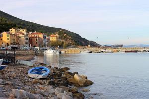 un pequeño barco en la orilla de un cuerpo de agua en La Dimora nel Parco - ArgonautiVacanze, en Rio Marina