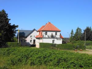 una casa blanca con techo rojo en una colina en Willa Kotwica, en Jastrzębia Góra