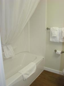y baño blanco con bañera y toallas. en Paddock Inn, en Coleman