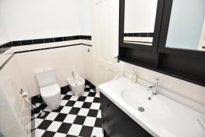 a bathroom with a black and white checkered floor at Casa Pé da Cabra in Coimbra +18 photos