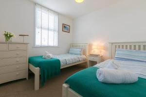 a bedroom with two beds and a dresser at Sea Ayr in St Ives