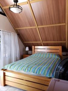 Cama en habitación con techo de madera en Hostal Finca Ely, en Tambo