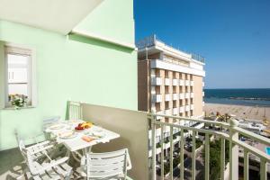 un balcón con mesa y sillas y un edificio en Beach Residence, en Gabicce Mare