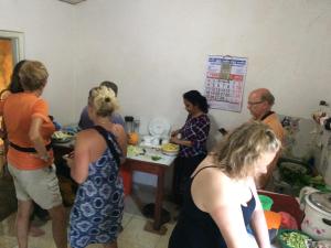 un gruppo di persone che si trovano intorno a un tavolo con cibo di Takeshi Inn a Dambulla