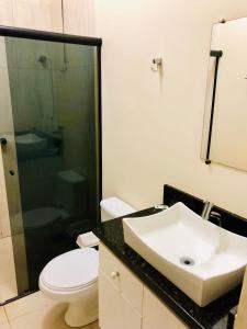 Porto Verde Hotel في لينس: حمام مع حوض ومرحاض ودش
