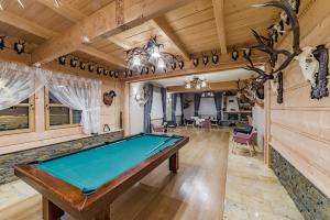 a pool table in a room with wooden ceilings at Pensjonat Dziubas - 5 minut na piechotę do stacji narciarskiej Kotelnica i term Bania, parking przy obiekcie in Białka Tatrzanska