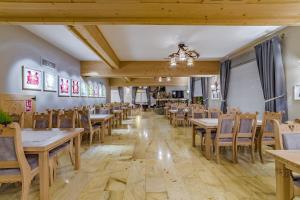 a dining room with wooden tables and chairs at Pensjonat Dziubas - 5 minut na piechotę do stacji narciarskiej Kotelnica i term Bania, parking przy obiekcie in Białka Tatrzanska