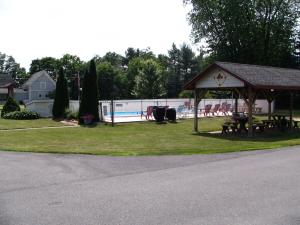 a gazebo with a picnic table and a pool at Maple Leaf Motel in Littleton
