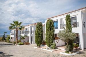 a large white building with trees in front of it at Julipapas Gardens in Paphos