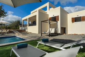 a villa with a swimming pool and a house at Villa Aigües Blanques in Es Figueral Beach