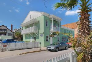 une maison verte avec une voiture garée devant elle dans l'établissement Bella Bay Inn, à Saint Augustine