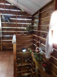 una habitación con una pared de madera con plantas. en Hostal Finca Ely, en Tambo