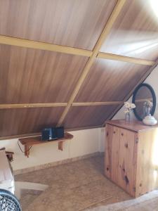Habitación con techo de madera y mesa de madera. en Hostal Finca Ely, en Tambo