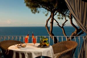 a table with drinks and fruit on a balcony with the ocean at Le Querce Resort Sea Thermae & Spa in Ischia